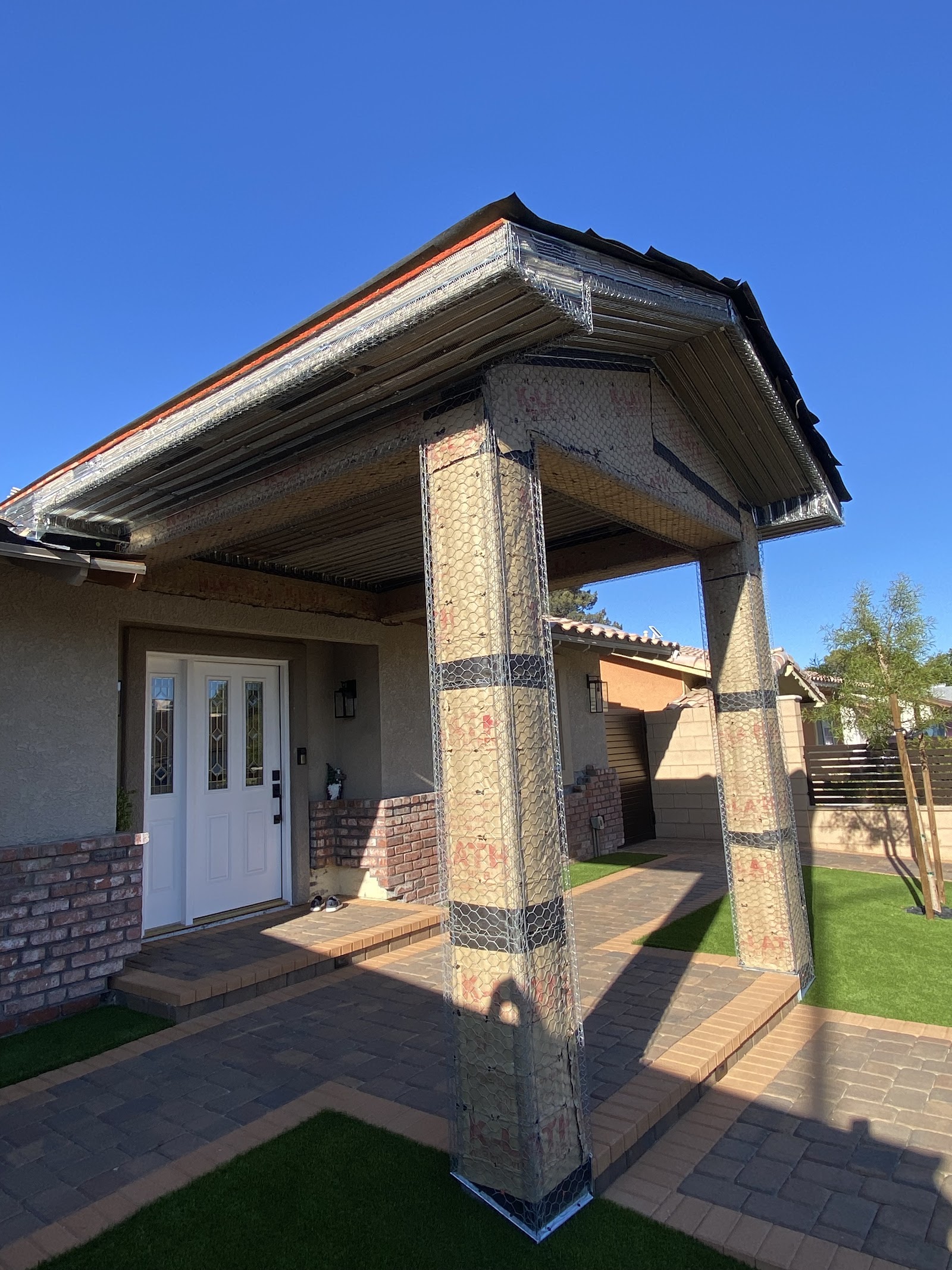Porch columns and eave framed with metal lath ready for stucco, daytime
